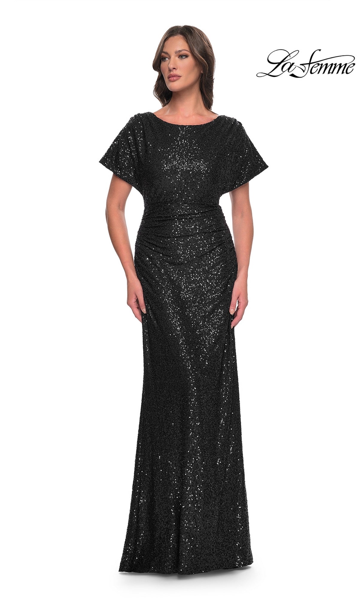 A woman models the La Femme Short-Sleeve Sequin Formal Dress 30885, a fitted, floor-length black gown, against a plain white background with the